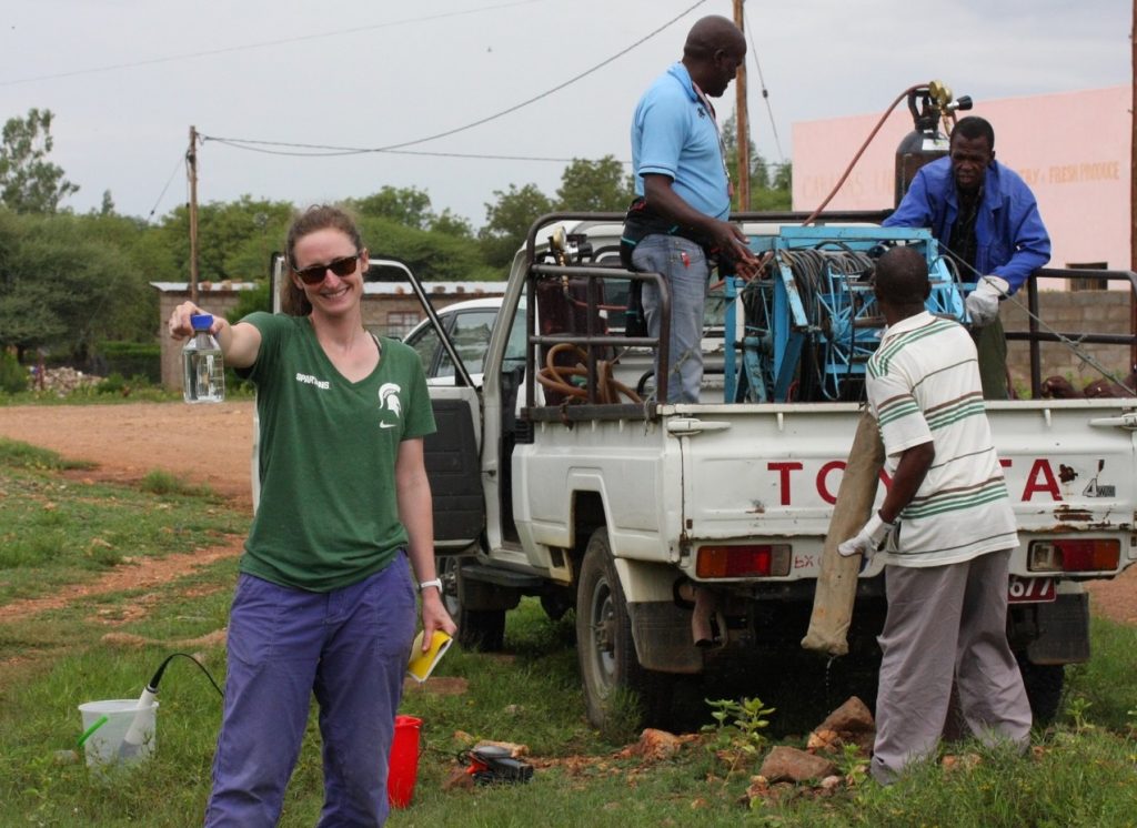 After pumping a monitoring borehole in Ramotswa with the Botswana Geological Institute crew (from left, me, Mr. Victor Mathumo, Mr. Simon Thumpe, and Mr. Aupa Kgobe). (Photo courtesy of Bonnie McGill)