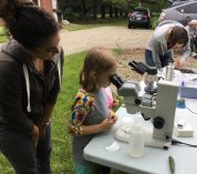 Postdoc Tatiana Severin helps Lillian Haas look through a microscope