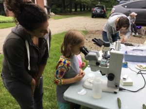 Postdoc Tatiana Severin helps Lillian Haas look through a microscope