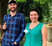 Sean Griffin and Meredith Zettlemoyer stand outside, smiling at the camera.
