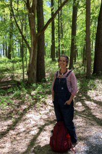Erin Schneider stands under a canopy of trees on the Kellogg Biological Station's Farm Trail.