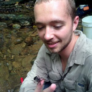 Kyle Jaynes examines a wheel bug (Arilus sp.) crawling on his finger while in Trinidad.
