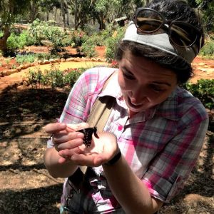Meredith Zettlemoyer examines a butterfly in the field.