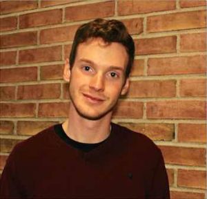 Head shot of Harry Ervin standing against a brick wall. 