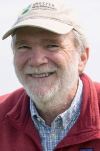 Portrait of Dr. Phil Robertson wearing a tan baseball cap and red jacket.