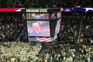 The jumbotron at MSU's Breslin Center shows a smiling Jim Allen, who was being recognized for his military service.