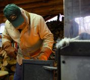 A volunteer feeds the fire at the Kellogg Forest sugar shack.