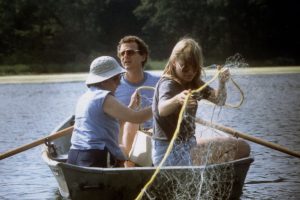 Don Hall sits in a rowboat with two colleagues, gathering samples on Wintergreen Lake.