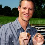 Photo of Fred Janzen holding two small turtles.