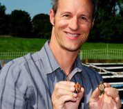 Photo of Fred Janzen holding two small turtles.