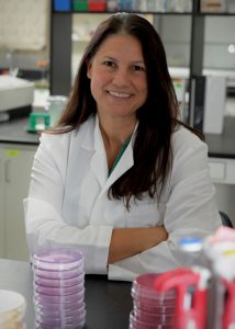 Shannon Manning, MSU Foundation Professor, stands among petri dishes in a laboratory. Credit to Harley J. Seeley.