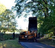 Paving equipment lays a layer of asphalt on a section of the Paved Path.