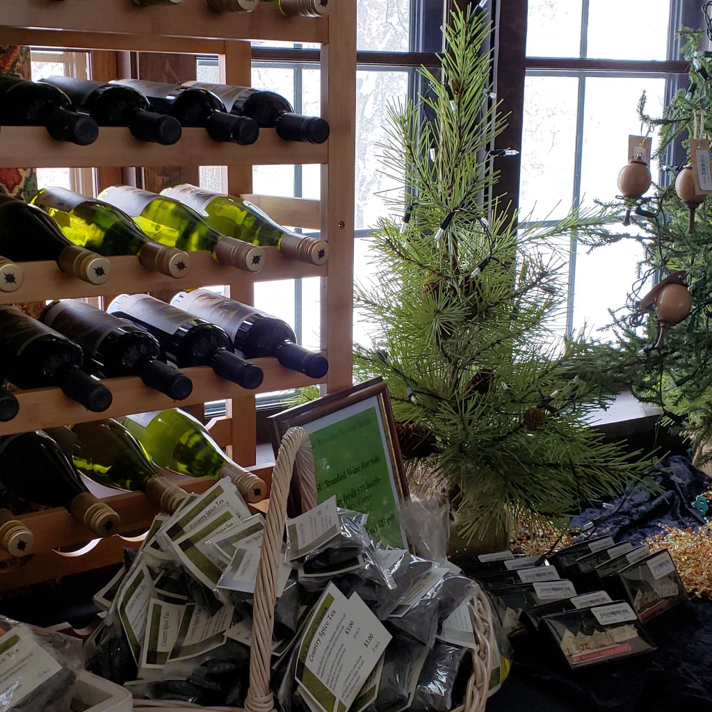 Bottles of Michigan State University wine and bundles of tea sit on a table beside a small Christmas tree at the W.K. Kellogg Manor House.