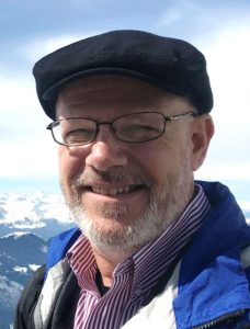 James Grace stands on Switzerland's Mt. Pilatus, overlooking mountains.