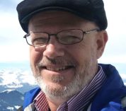 James Grace stands on Switzerland's Mt. Pilatus, overlooking mountains.