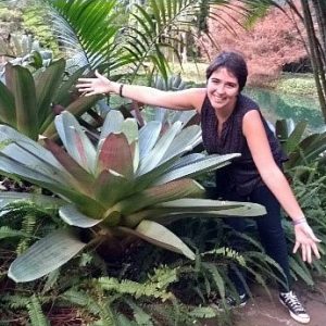 Isabela Lima Borges poses with a large succulent plant.