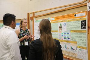 KBS summer student presents their research poster to guests at the summer student sypmosium