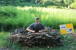 A summer 2022 KBS students sits in the eagle nest display at the W.K. Kellogg Bird Sanctuary.