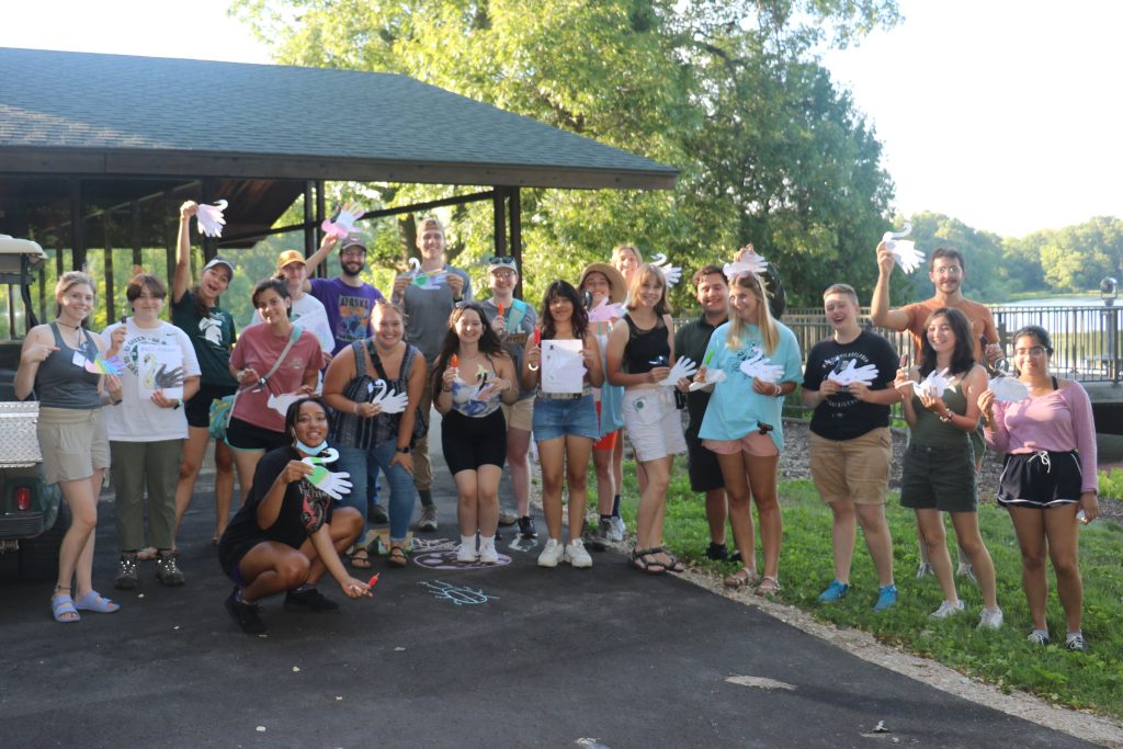 A group of 2022 summer students pose at the W.K. Kellogg Bird Sanctuary holding crafts they made.