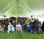 Concertgoers sit under a tent at the W.K. Kellogg Biological Station grounds during a past Lakeside Concert event.