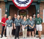 Manor House volunteers pose outside the front door of the manor.