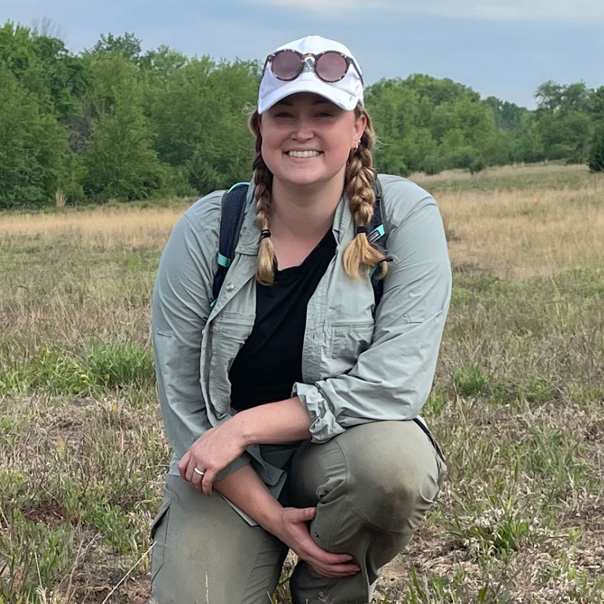 Morgan Clark pictured in a grassy field with trees in the background.