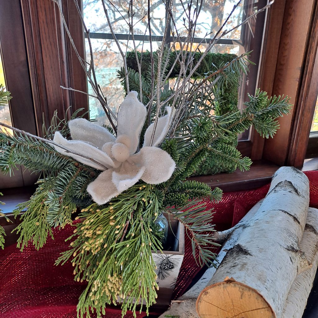 A small evergreen tree and other items for sale are displayed on a window seat at the W.K. Kellogg Manor House's Holiday Market.
