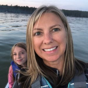Photo of Julie Melotti in a canoe with a young child.