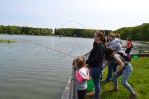 Students and educators react after they pull a fish out of Wintergreen Lake.