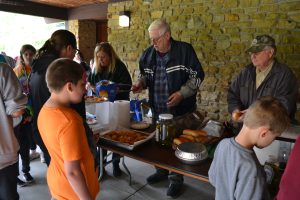 Volunteers serve food to a line of students and educators outside of the Bird Sanctuary’s Resource Center.