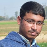 Head shot photo of Ashim Datta, with a field in the background.