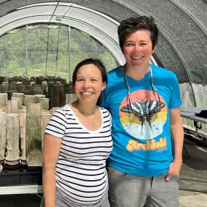Cinnamon Mittan-Moreau (left) and Sarah Fitzpatrick pose for a photo in a hoop-house structure.