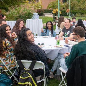 Envision EEB attendees sit around a round table outdoors on Michigan State University’s campus in East Lansing.