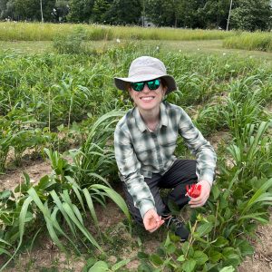 Robin Waterman smiles while crouching near the ground to examine the emergence of one of her study species. Credit: Kate Shaw.