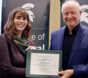 Holly Vander Stel stands with MSU College of Natural Science Dean Phillip Duxbury, holding the certificate for her support staff award honor.