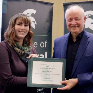 Holly Vander Stel stands with MSU College of Natural Science Dean Phillip Duxbury, holding the certificate for her support staff award honor.