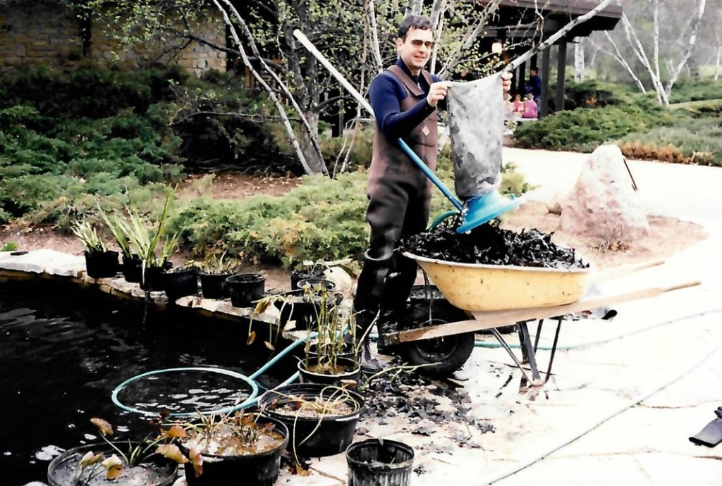 Stu Bassett cleans out the Light Memorial Water Garden at the Kellogg Bird Sanctuary.