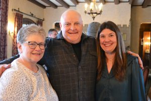 Jim Allen, Carol Marbach, and Nicole Kokx post for a photo at Allen’s retirement reception.