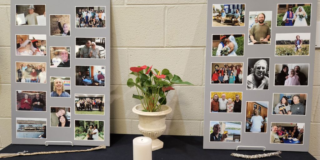 Photo displays in memory of Andy Fogiel sit atop a table along with flowers and other mementos.