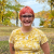 Erica Bradshaw stands outside on an autumn day with colorful trees and a lake in the background.
