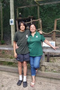 Student Cassius Caldwell and MSU staff member Stephanie Chau pose in front of the eagle enclosure at the W.K. Kellogg Bird Sanctuary.