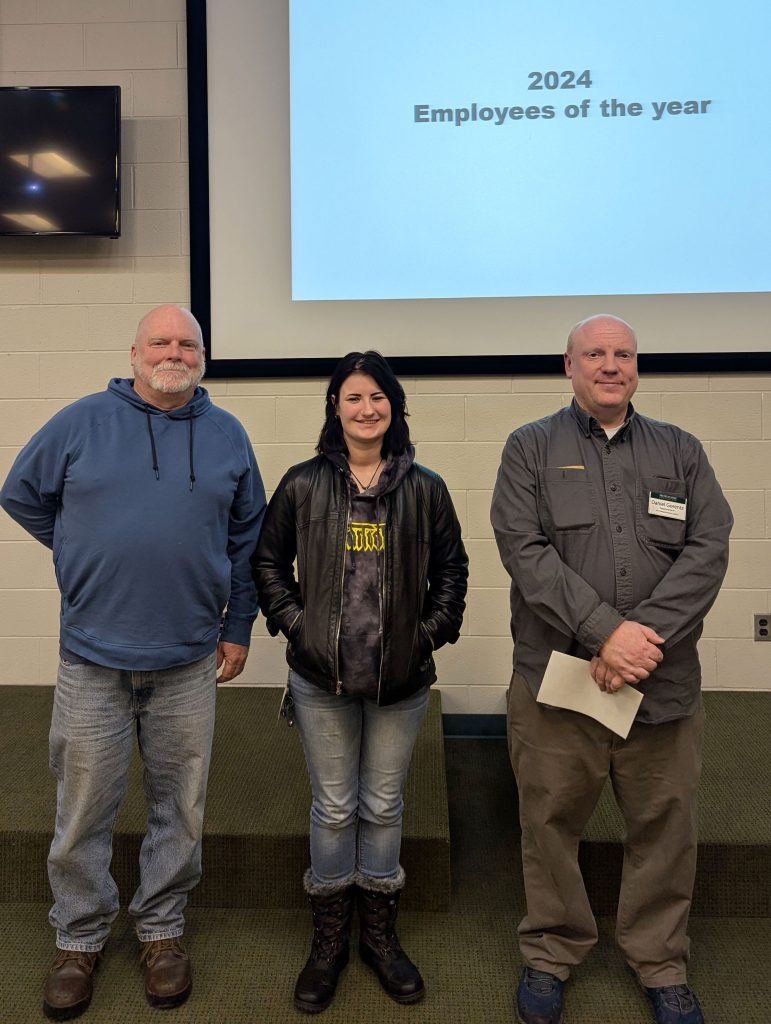 From left, Kevin Kahmark, Sierra Amyx, and Daniel Gorentz stand in the KBS Auditorium after being named Employees of the Year for 2024.