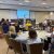 Data Nuggets Fellow Samson Stynen speaks to a room full of educators seated at round tables.