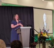 Sarah Reimer speaks from a podium during the ceremony honoring 2024-25 Jack Breslin Distinguished Staff Award recipients.