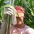 Cherith Pickett stands in a corn field holding a soil sampling tool.
