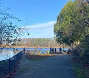 People gather off the W.K. Kellogg Bird Sanctuary's Paved Path on the shore of Wintergreen Lake to view birds on an autumn day.