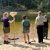 Several GALS participants stand on sand at the water's edge, holding fish nets, while an employee from the Michigan Department of Natural Resources talk with them about aquatic ecology.