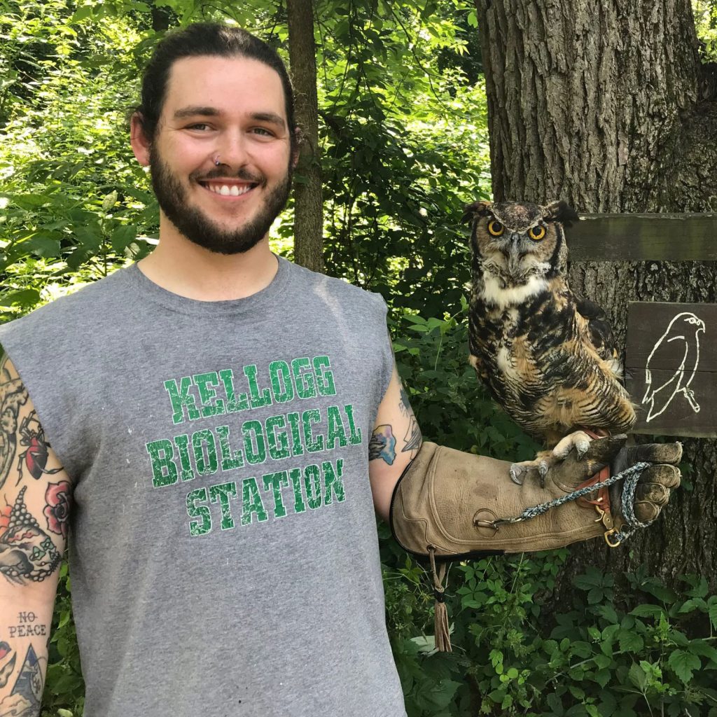 Brenden Kokx stands at the Kellogg Bird Sanctuary holding Virginia, a great-horned owl.