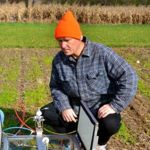 Sven Bohm inspects equipment in the field at the KBS Long-Term Ecological Research program.
