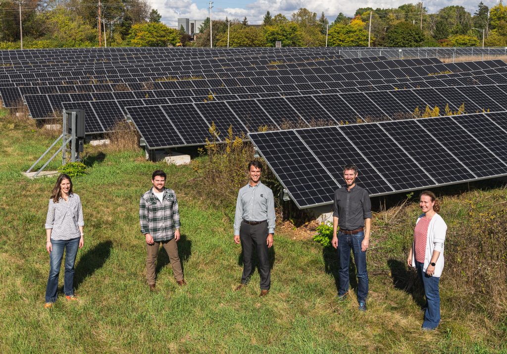 MSU researchers stand near a solar array in a grassy area. Pictured from L-R: Phoebe Zarnetske, Jake Stid, Anthony Kendall, Adam Zwickle and Annick Anctil. Credit: Finn Gomez